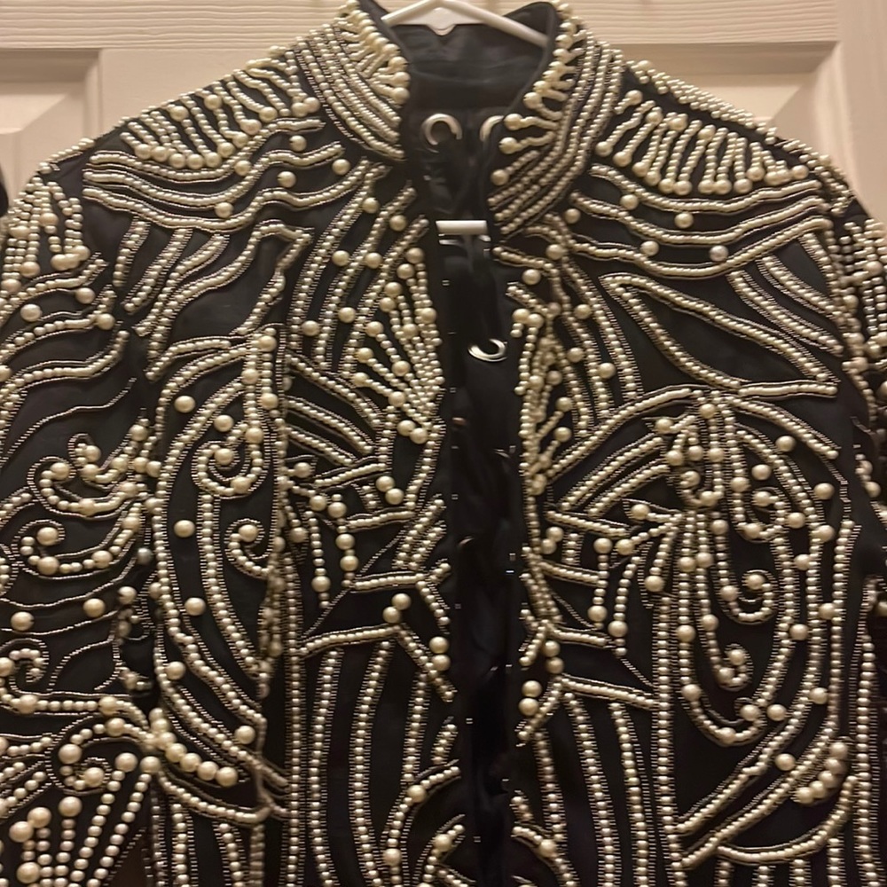 Pearl embellished black jacket with tie in the back.